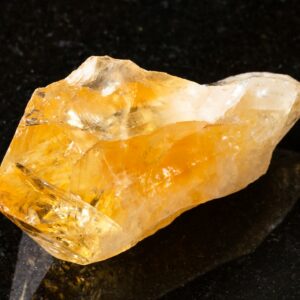 raw crystal of Citrine gemstone on black